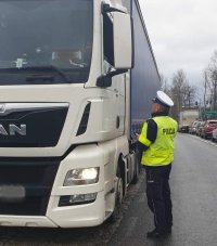 policjant kontroluje kierującego samochodem ciężarowym
