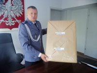 Komendant Miejski Policji w Piotrkowie Trybunalskim z prezentem przekazanym od starostwa