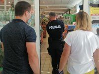 policjanci z pracownikami sanepidu wchodzą do sklepu