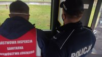policjant z pracownikiem inspekcji sanitarnej przeprowadza kontrole w autobusie miejskich linii