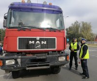 na zdjęciu widać przód samochodu ciężarowego i dwóch policjantów ruchu drogowego