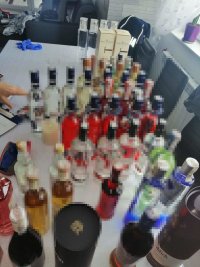 na zdjęciu widoczne butelki szklane z różnego rodzaju alkoholem, z polskim znakiem akcyzy, które zostały odnalezione podczas przeszukania jednego z zatrzymanych mężczyzn.