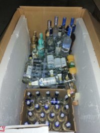 butelki z alkoholem w pudełku kartonowym zabezpieczone w trakcie przeszukania