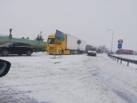 na zdjęciu widoczna droga pokryta dużą pokrywą śniegu, widoczne na zdjęciu pojazdy ciężarowe i osobowe