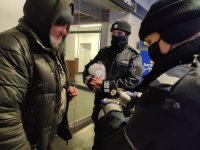 policjantka częstuję bezdomnego mężczyznę gorącą herbatą