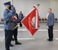 Poczet sztandarowy oddaje honory, komendant piotrkowskiej jednostki stoi przed sztandarem