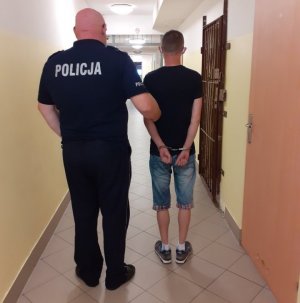 policjant z zatrzymanym w korytarzu
