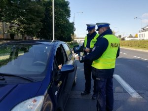 policjanci ruchu drogowego kontrolują kierowcę samochodu osobowego