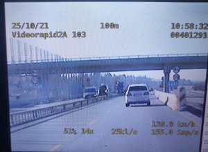 widok z nagrania wideorejestratora w policyjnym radiowozie, na zdjęciu widoczny pojazd jadący remontowanym odcinkiem autostrady a1, po prawej stronie znak ograniczenia prędkości do 70 km/h