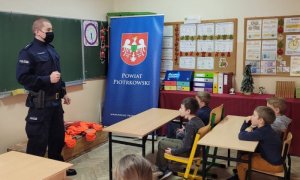policjant gorzkowickiego komisariatu w klasie szkolnej rozmawia z pierwszoklasistami o bezpieczeństwie