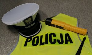 kamizelka z napisem policja, na niej czapka policyjna oraz urządzenie do badania stanu trzeźwości