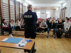 policjant podczas spotkania doborowego z młodzieżą na terenie Zespołu Szkół Ponadpodstawowych Nr 5 w Piotrkowie