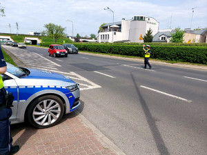 policjantka na jezdni daje sygnał kierowcy przy użyciu tarczy do zatrzymania pojazdu