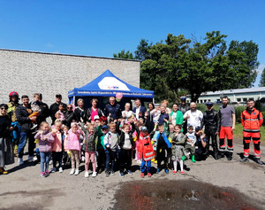 zdjęcie grupowe , policjanci i inne służby ratunkowe  oraz przedszkolaki podczas pikniku z okazji Dnia Dziecka