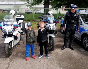 policyjni motocykliści wspólnie z dwoma chłopcami z grupy przedszkolnej