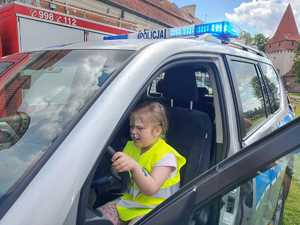 dziewczynka siedzi w radiowozie policyjnym