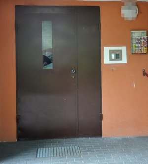 na zdjęciu wybita szyba w drzwiach wejściowych do klatki bloku mieszkalnego