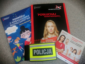 ulotki informacyjne oraz zeszyty edukacyjne na temat bezpieczeństwa w rejonach przejazdów kolejowych, oraz policyjna opaska
