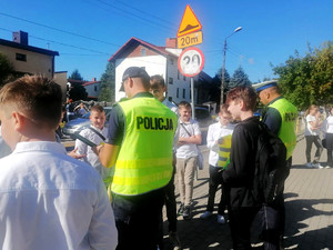 policjant ruchu drogowego i dzielnicowy rozmawiają z uczniami o bezpieczeństwie