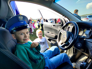 chłopiec w policyjnym radiowozie w policyjnej czapce