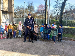 na zdjęciu policjant z policyjnym psem służbowym oraz dzieci z grupy przedszkolnej