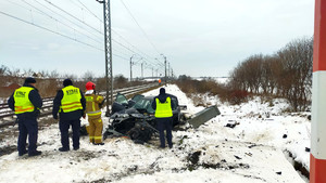 Policjanci wykonują oględziny miejsca wypadku na niestrzeżonym przejeździe kolejowym