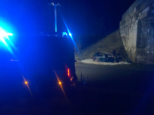 radiowóz na miejscu zdarzenia, w tle rozbity pojazd
