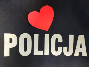 Napis Policja na mundurze, obok czerwone serce