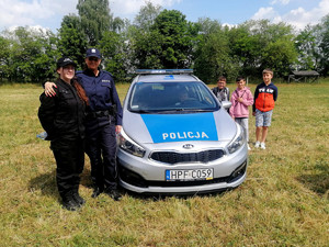 na zdjęciu policyjny radiowóz, policjantka z uczennicą klasy policyjnej z ZSCKZ w Bujnach.