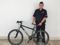 policjant zabezpieczający odzyskany rower