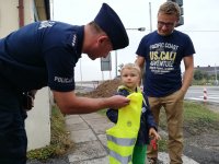 Policjant zakładka dziecku kamizelkę odblaskową