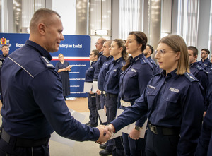 Komendant wręcza akt mianowania policjantom.