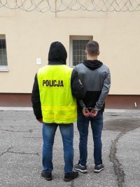 policjant prowadzi zatrzymanego