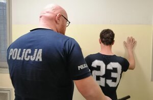 policjant prowadzi zatrzymanego