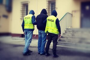 policjanci prowadzą zatrzymanego