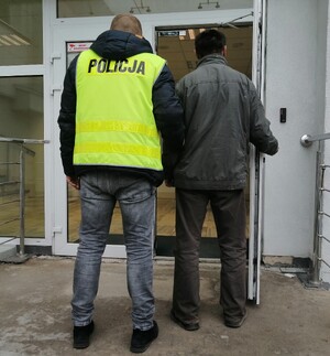 policjant prowadzi zatrzymanego