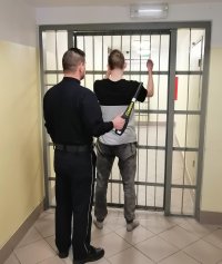 policjant prowadzi zatrzymanego