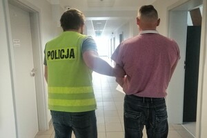 policjant prowadzi zatrzymanego mężczyznę