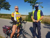 policjant rozmawia z rowerzystą o bezpieczeństwie w ruchu drogowym