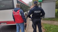 policjant z pracownikiem inspekcji sanitarnej na przystanku autobusowym