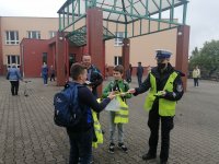 policjanci rozdają dzieciom elementy odblaskowe