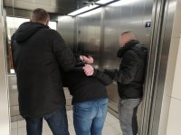 policjanci z zatrzymanym w windzie w galerii handlowej