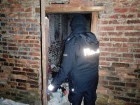 policjantka zaglądająca do opuszczonego pomieszczenia przy pustostanie