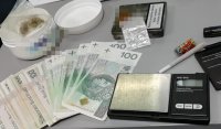 na zdjęciu zabezpieczone środki odurzające w pudełku po kremie, metalowa puszka oraz pieniądze i waga