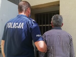 policjant prowadzi zatrzymanego