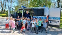 policjant przy radiowozie oznakowanym razem z grupą przedszkolną