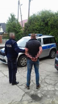 policjant prowadzi zatrzymanego