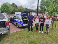 policjant z dziećmi przy radiowozie