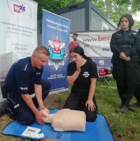 policjant przedstawiający zasady dokładnego wykonania resuscytacji krążeniowo oddechowej