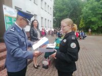Zastępca komendanta piotrkowskiej jednostki wręcza podziękowania dla uczennicy klasy policyjnej